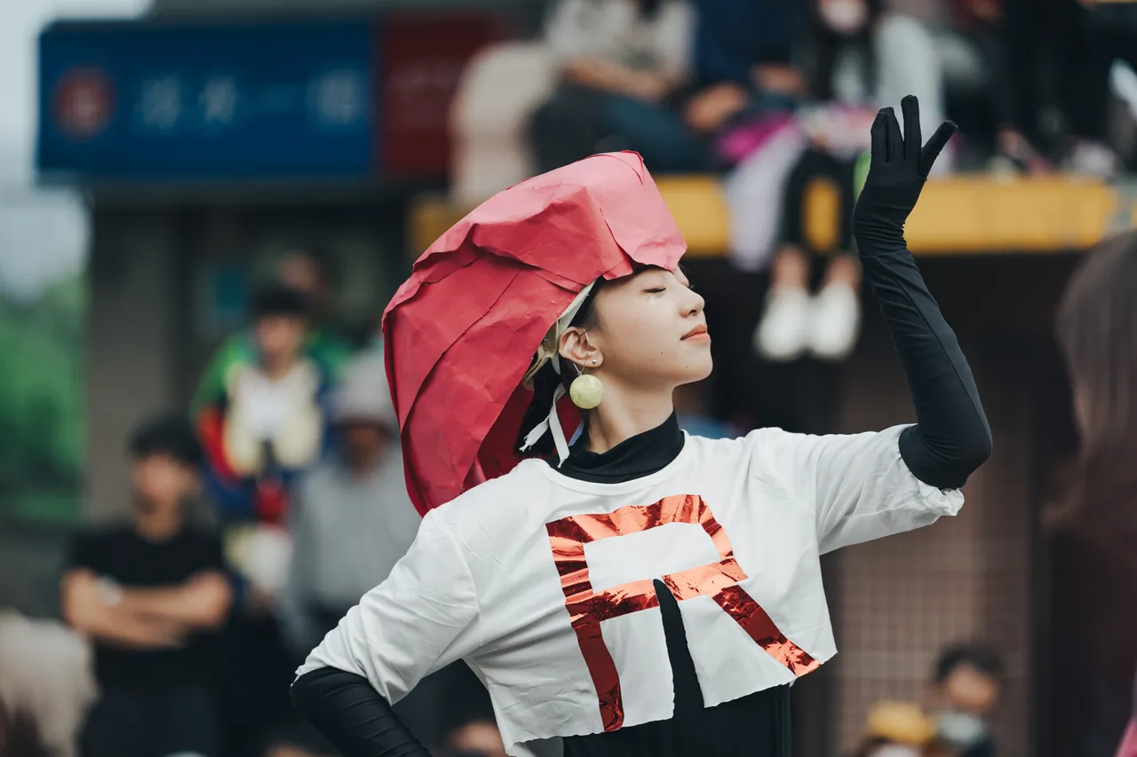 戴帽子並伸手互動的表演者